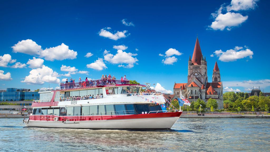 Ein Schiff auf der Donau und im Hintergrund eine Kirche