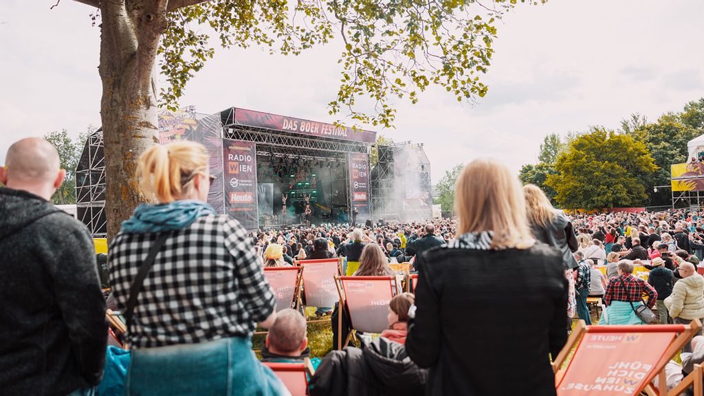 Entfernter Blick auf die Bühne vom Donauinsel Open Air Menschen und Liegestühlen