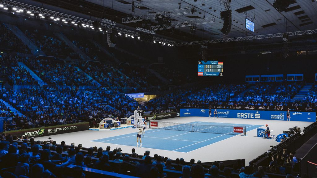 Ein Tennisplatz mit zwei Spielern und rundherum Tribünen mit Menschen