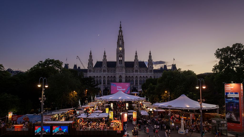 Der Rathausplatz mit vielen Ständen beleuchtet von oben 