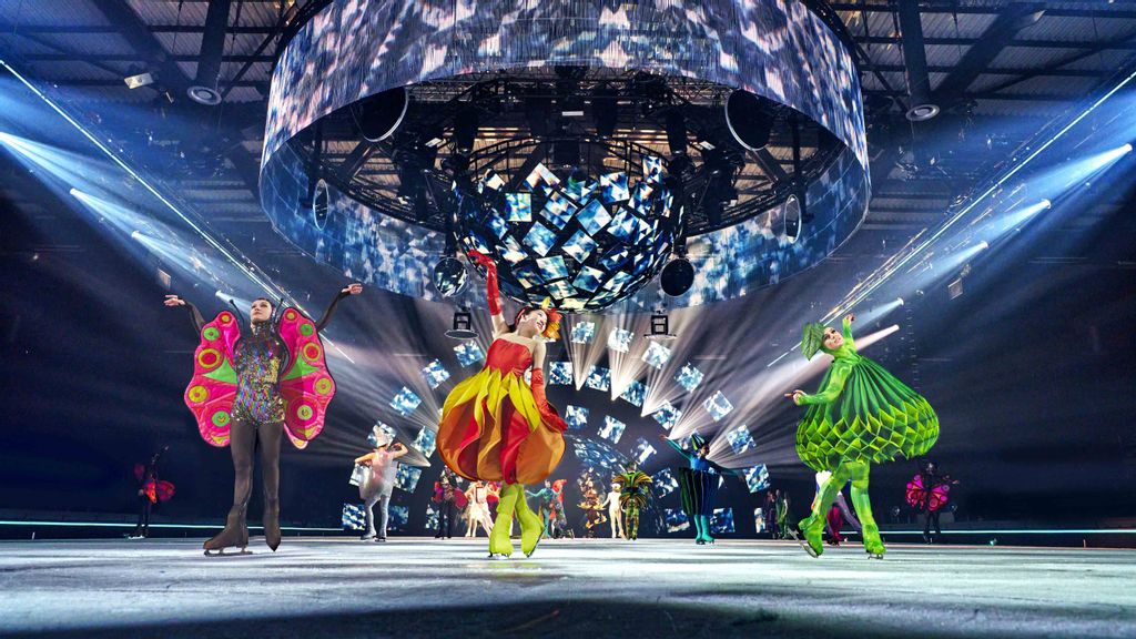 © Rico Ploeg_Holiday on Ice Kostümierte Eiskunstläufer*innen auf einer beleuchteten Eisfläche