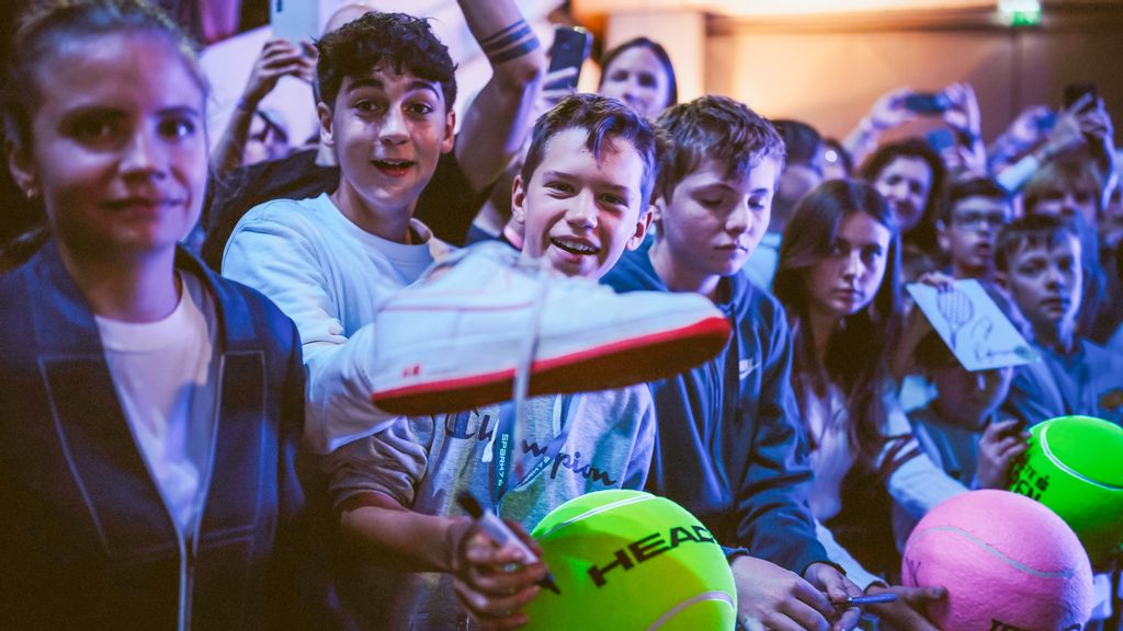 Menge an Personen, die große Tennisbälle halten