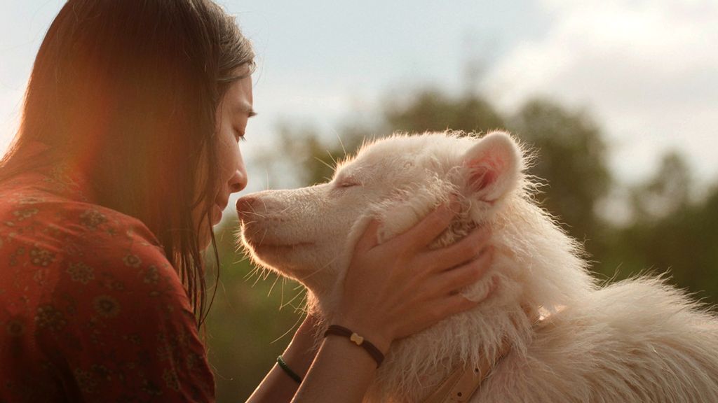Eine Frau hält ihre Nase mit geschlossenen Augen zu der Nase eines weißen Hundes