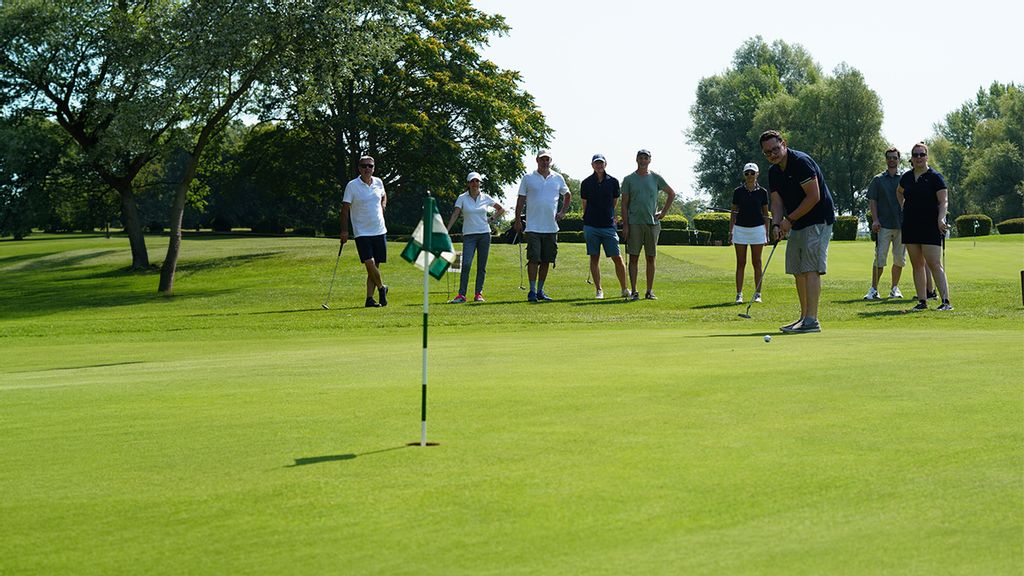 Personen am Golfplatz mit Ball und Schläger