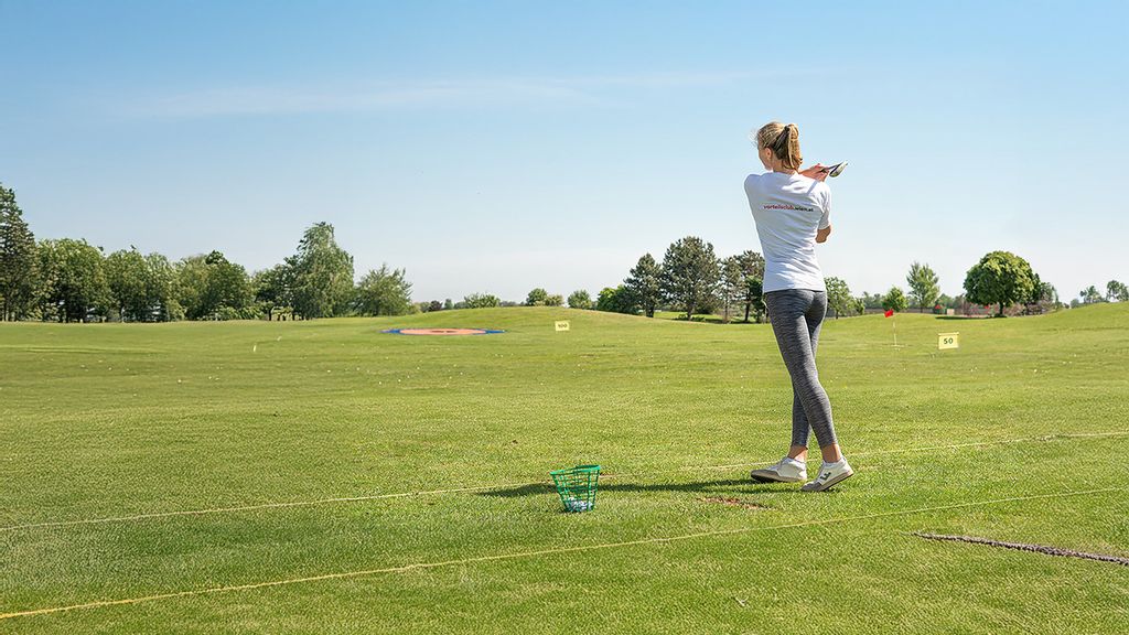 © stadt wien marketing gmbh Eine Frau, die einen am Golfplatz steht und einen Golfschläger schwingt