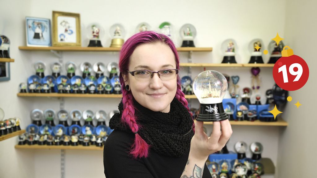 Eine Frau hält in ihrer Hand eine Schneekugel hoch