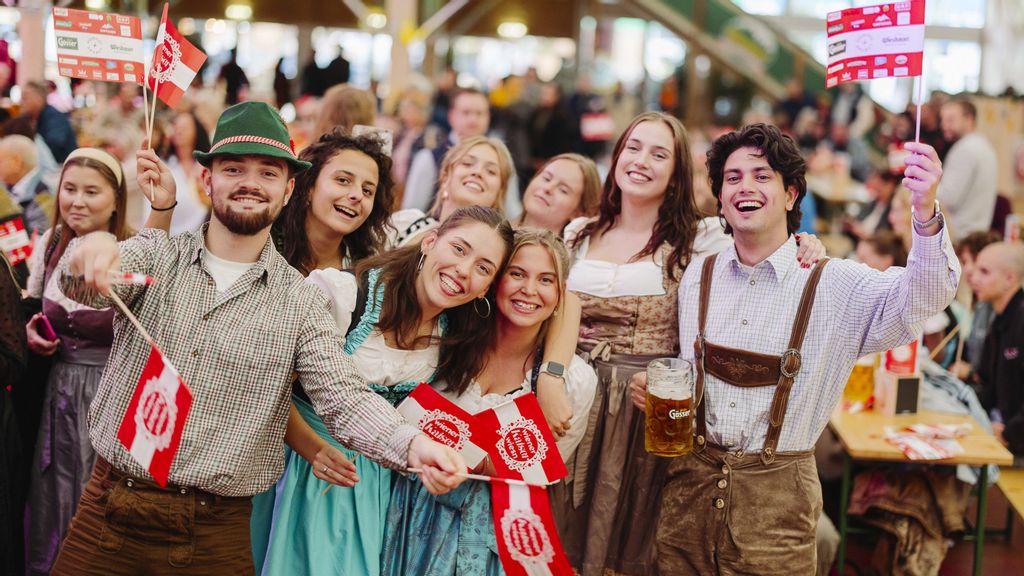 Eine Gruppe von Personen in Trachtenkleidung mit Österreich-Fahnen in der Hand