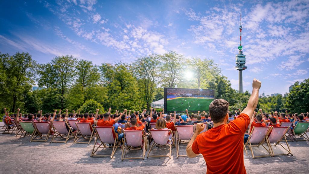 Leute, die auf Strandliegen sitzen und Fußball auf einer Leinwand schauen