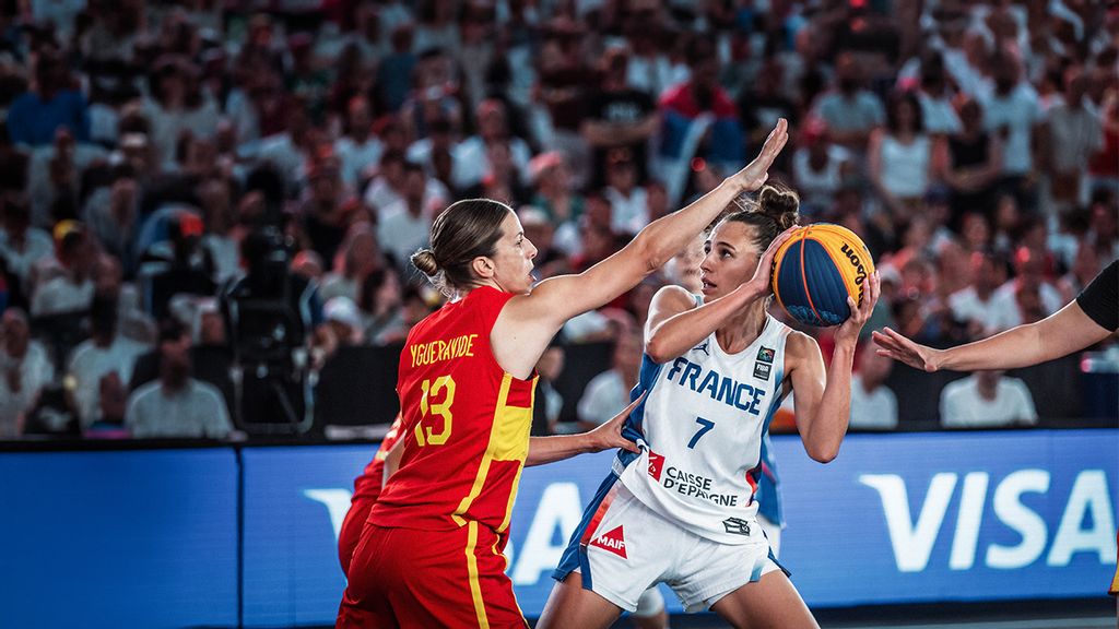 Zwei Basketballspielerinnen bei einem Turnier, eine davon hält einen Basketball in der Hand
