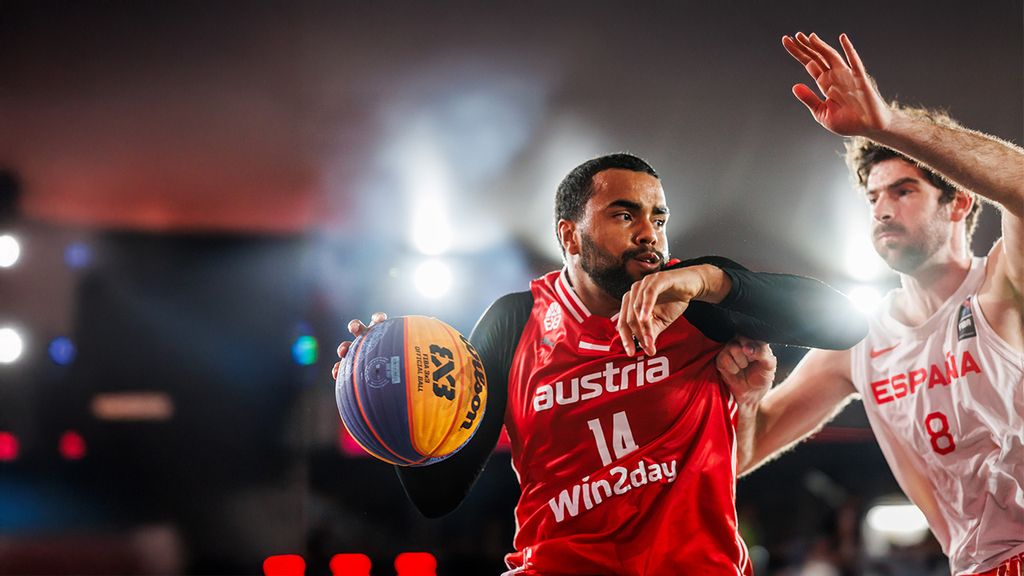 Zwei Basketballspieler beim Spielen und einer von ihnen hält einen Ball in der Hand 