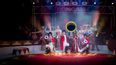 Eine Gruppe Artisten mit Kostümen auf auf einer Bühne im Zirkus