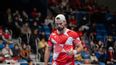 Tennisspieler in rot-weißem Outfit während eines Matches auf dem Court