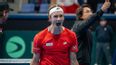 Tennisspieler im roten Outfit jubelt emotional auf dem Tennisplatz
